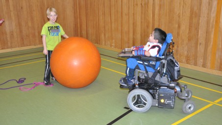 Ein Schüler im Rollstuhl spielt Riesenball